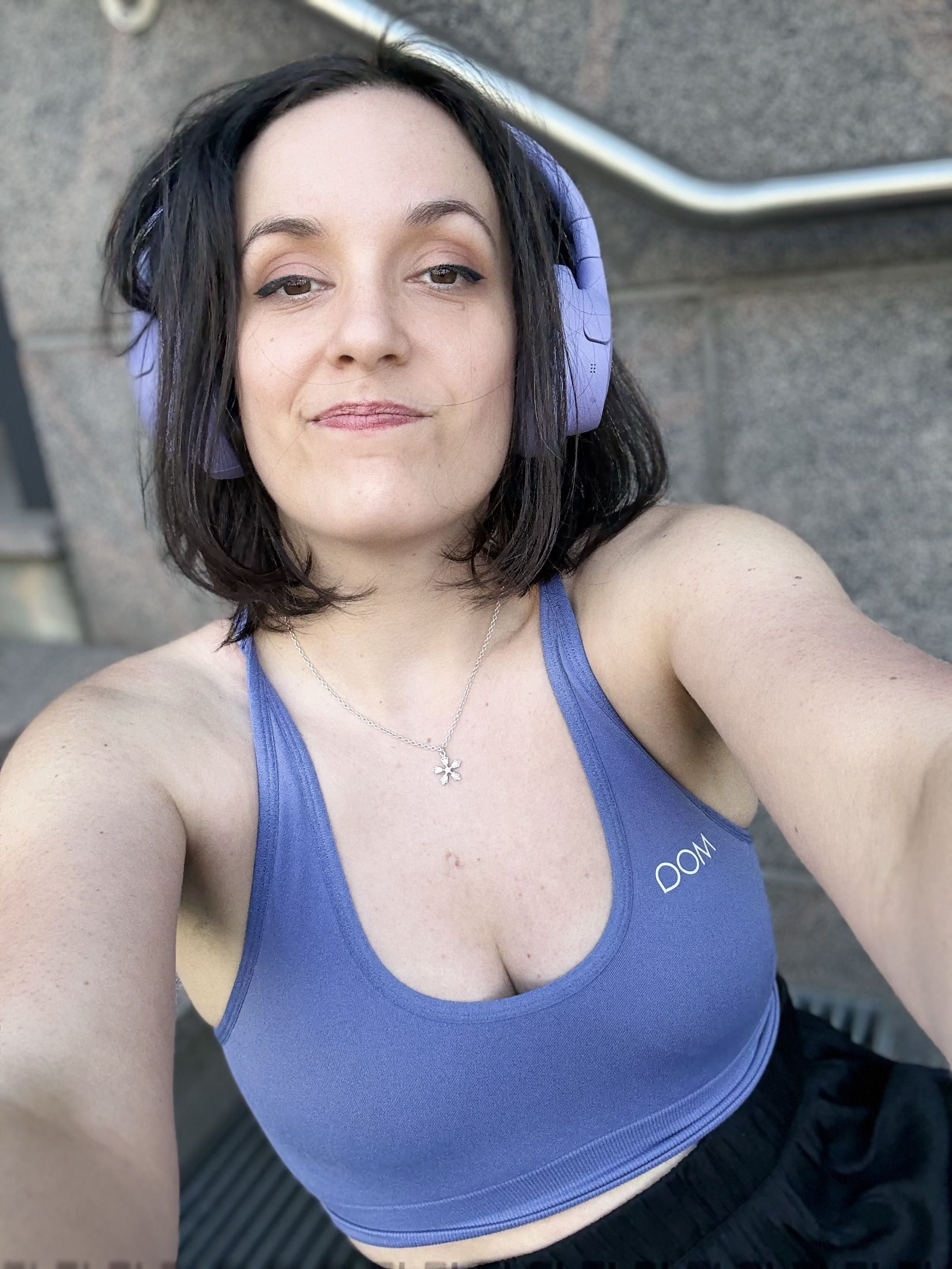 Elvann smiling in her studio, wearing glasses and headphones